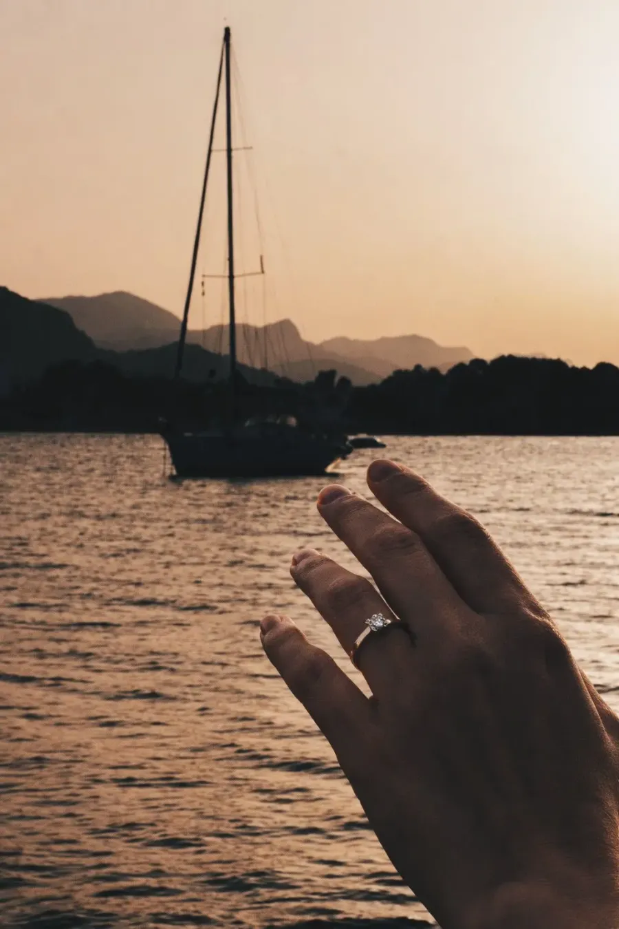 Anillo de compromiso con un velero al atardecer de fondo